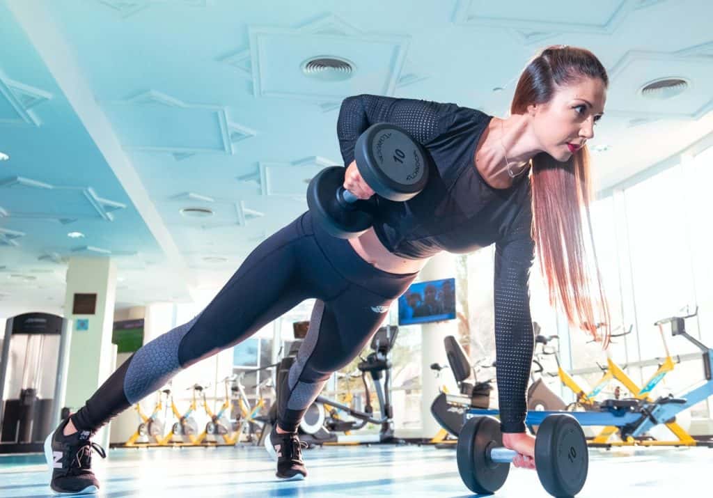 Woman using dumbbells in a gym