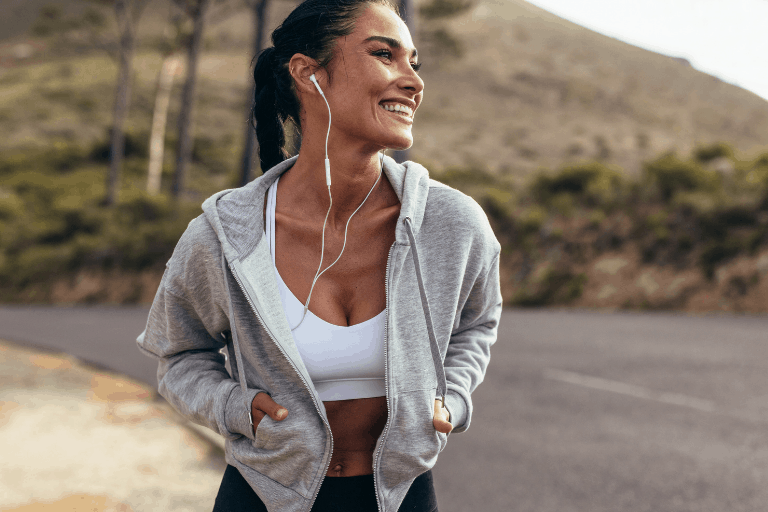 woman working out in the heat in sports bra and hoodie