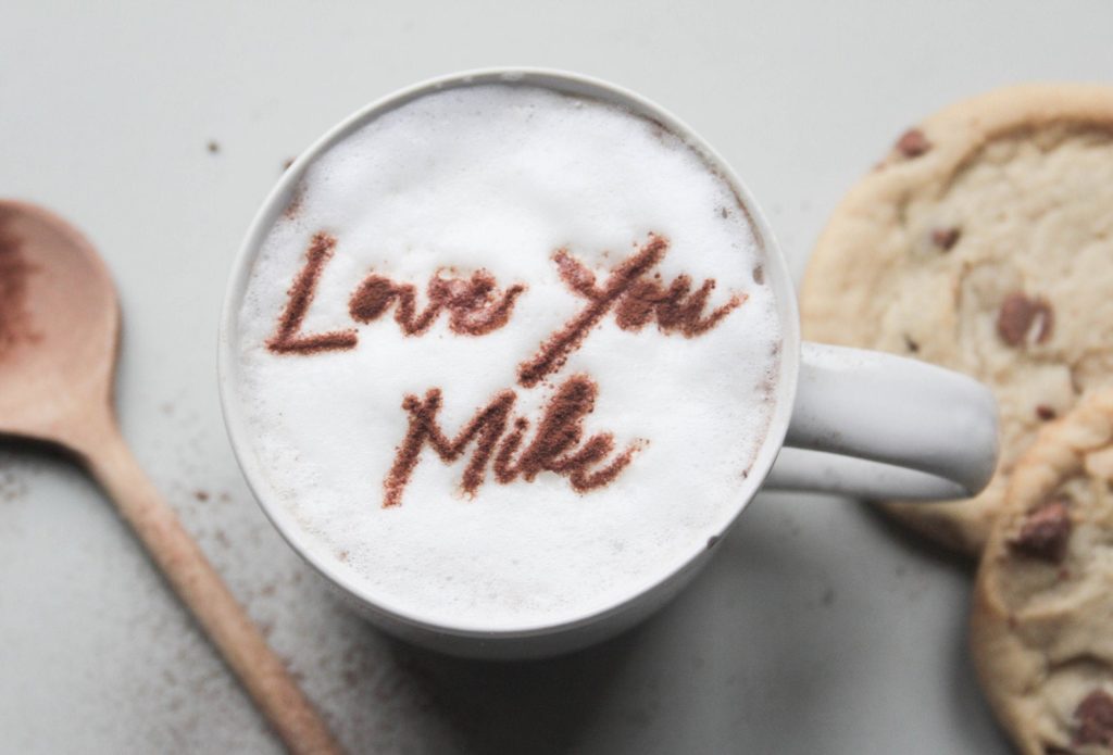 A foamy latte with "Love You Mike" written in cinnamon across the top