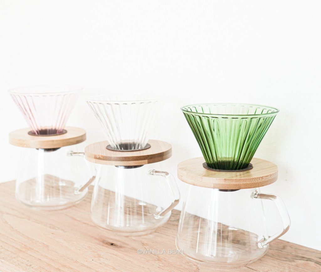 Three pastel coffee pour over sets in colors clear, green, and pink.
