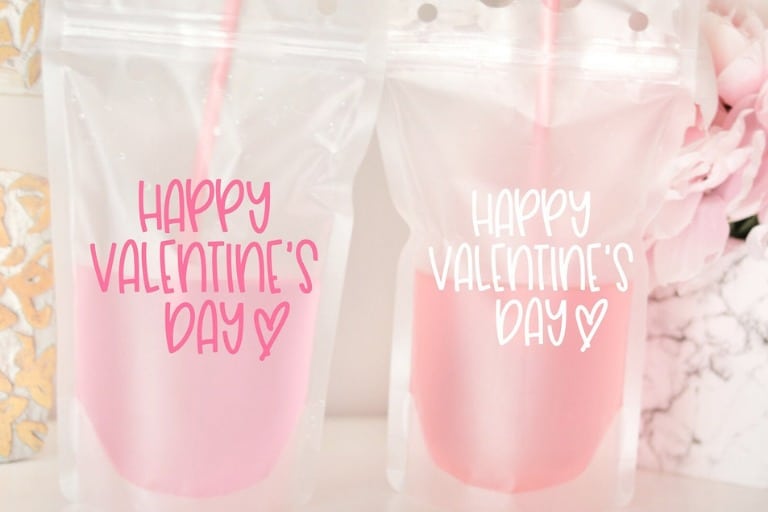Two plastic drink bags with pink beverages inside, with the bags reading "Happy Valentine's Day"